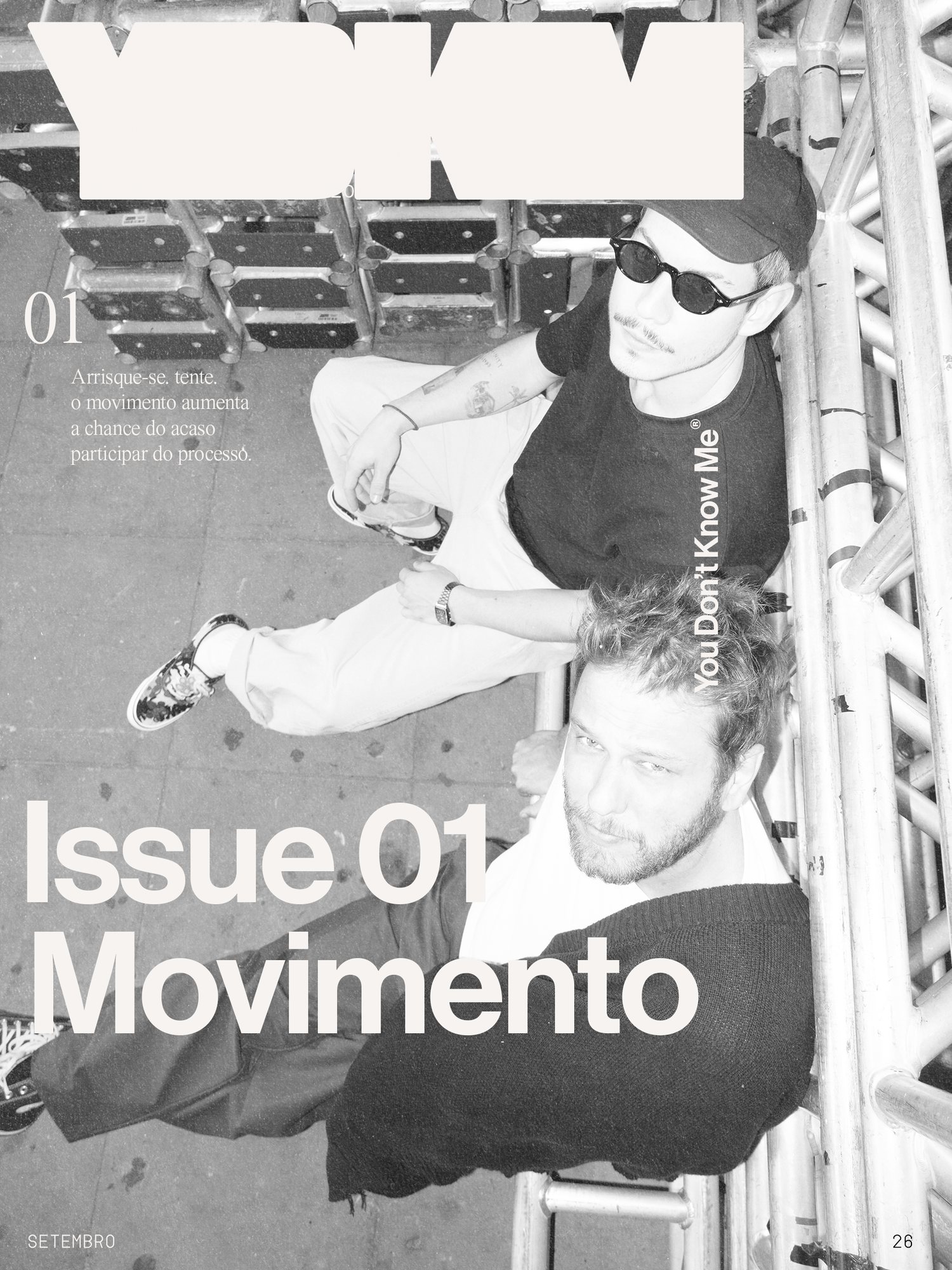 Capa da Issue 01 — Movimento: a dupla vista de cima, sentada numa estrutura de andaime, em preto e branco