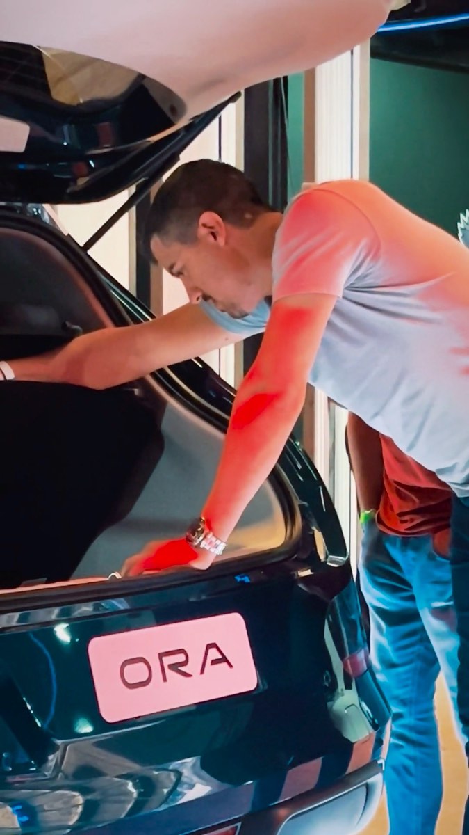Bastidor: alguém ajustando o carro no salão antes da gravação