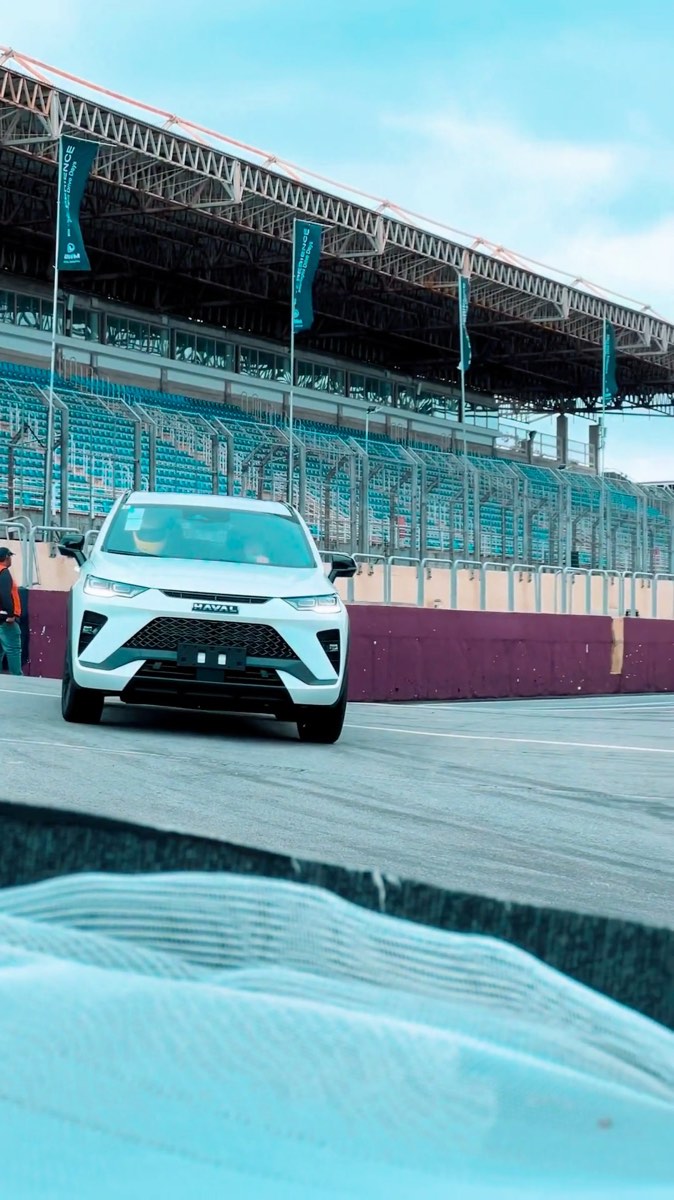 Carro vermelho sozinho na reta do autódromo, visto de cima