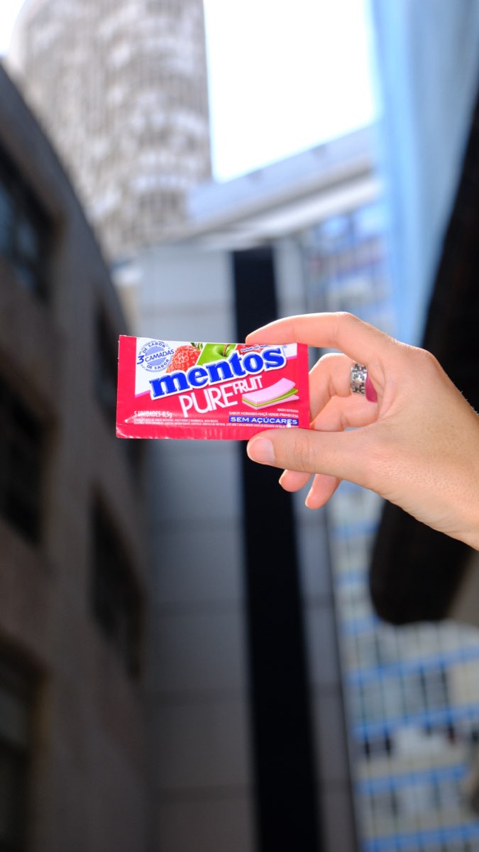 Pacote de Mentos contra uma torre de vidro, em contra-plongée
