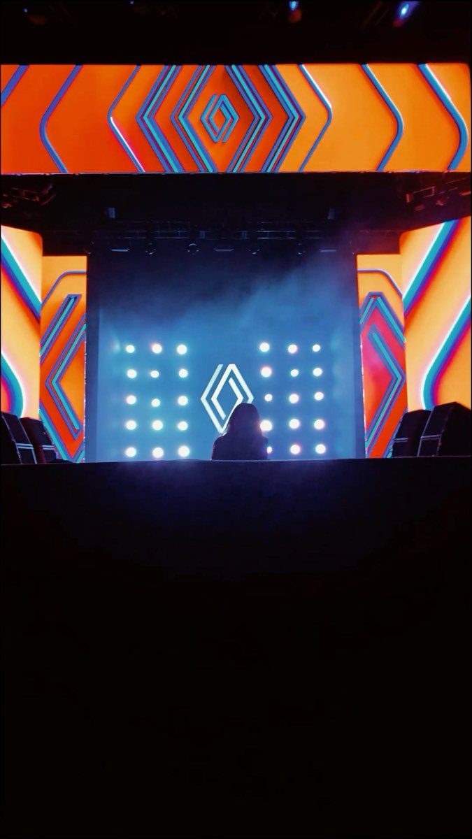 O palco do evento com o público e a fumaça